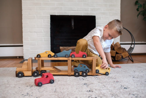 Boy playing with Wooden Truck Car Carrier