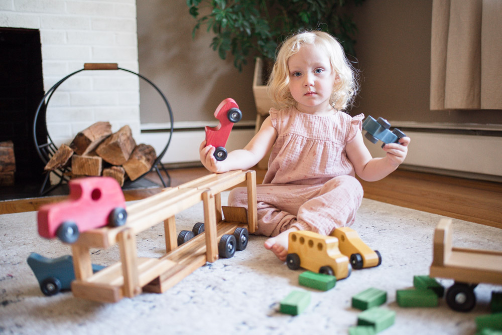 Girl Playing with Wooden Car Carrier Toy