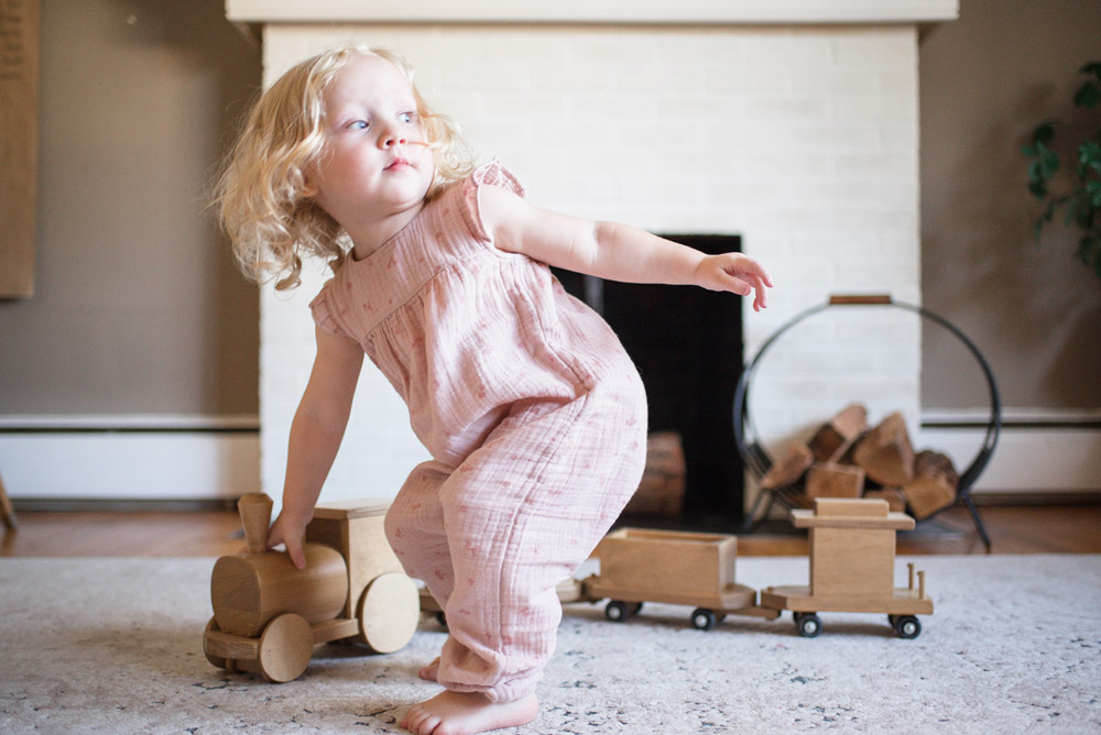 Girl Playing with Wooden Train Set