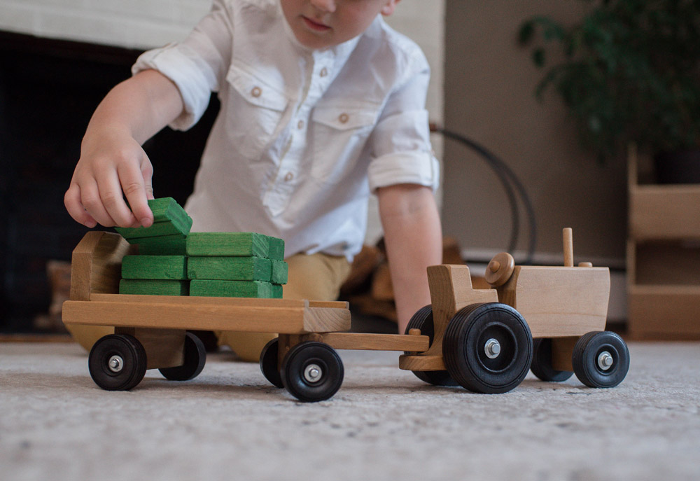 Boy playing with Wooden Tractor